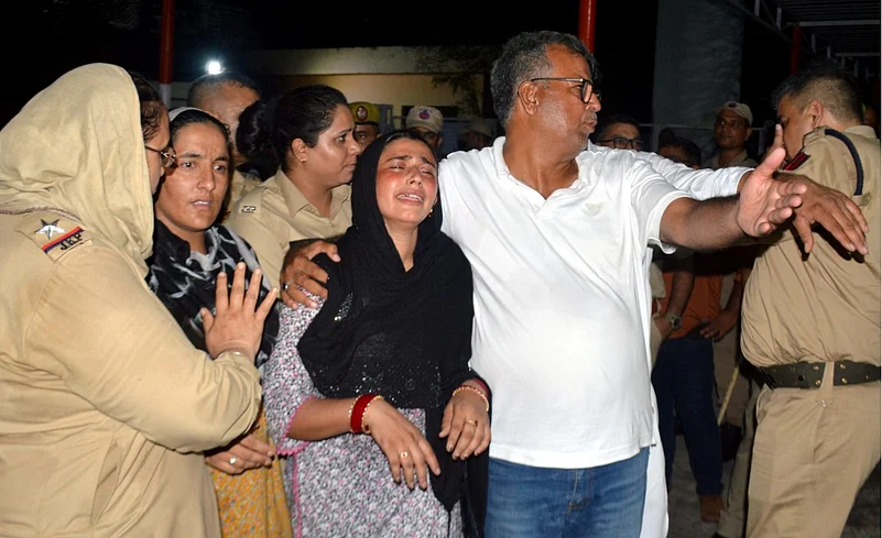 Bereaved family members of Parvaiz mourn outside the mortuary of a hospital, in Jammu.