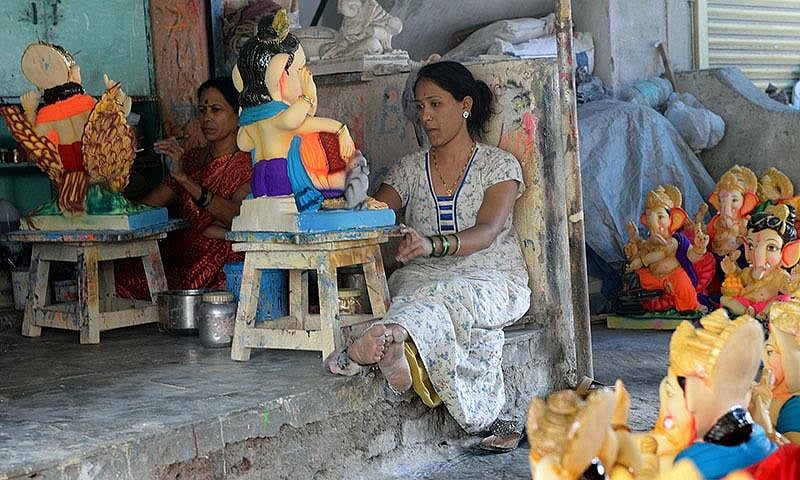 A woman is preparing a statue of Lord Ganesha