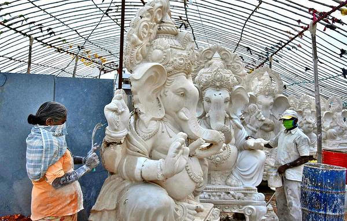 A woman and man are preparing a statue of Lord Ganesha