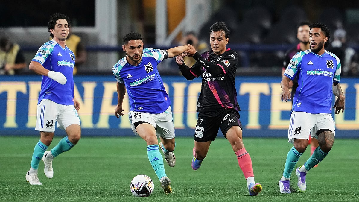 | Photo: AP/Lindsey Wasson : Seattle Sounders vs Puebla, Leagues Cup 2025: Puebla midfielder Fernando Monarrez (7) tries to fend off Seattle Sounders midfielder Cristian Roldan, second from left, as midfielder Paul Rothrock, far left, and forward Jesús Ferreira, far right, watch during the first half of a Leagues Cup quarterfinal soccer match Wednesday, Aug. 20, 2025, in Seattle.