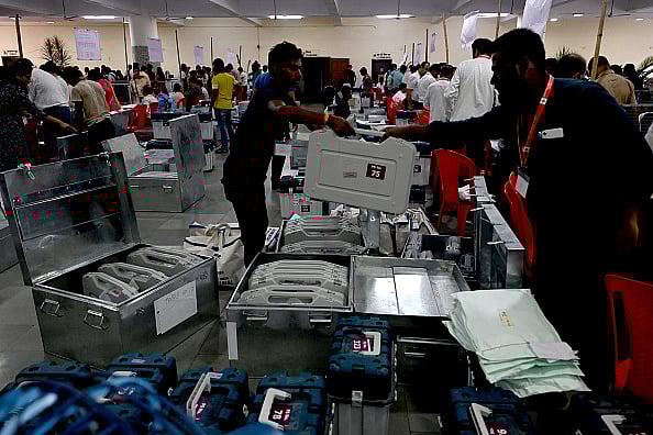 Election officials carry a (EVM) ballot box