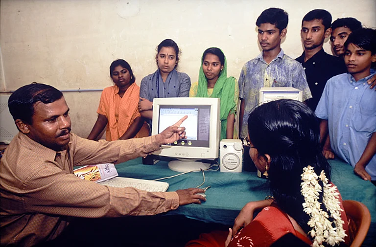 An instructor trains village teenagers to use of computers under the Akshaya Centre Scheme for the first e-literacy scheme achieved in Malappuram district, Kerala in 2004.
- Getty