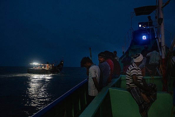 Getty : Fishermen sail to the sea at night on August 13, 2025 in Kochi, India.
