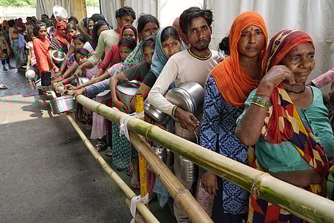 Hundreds wait for their turn to grab onto some food for their families as survival becomes more difficult. 