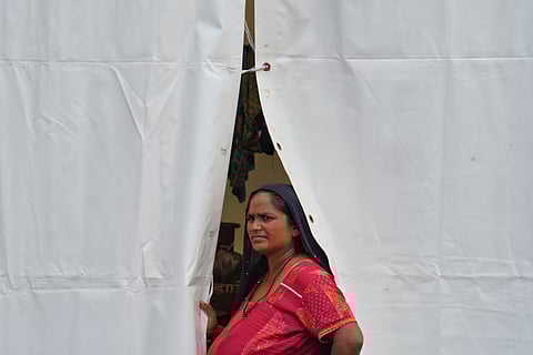 A woman stands tensed at the front of her tent at the Rahat Shivir Camp. 