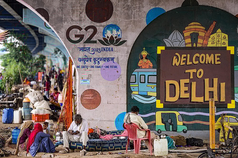 | Photo: PTI/Salman Ali : Flood-hit people take shelter under flyovers in Delhi