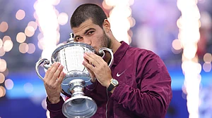 Carlos Alcaraz kisses the US Open trophy