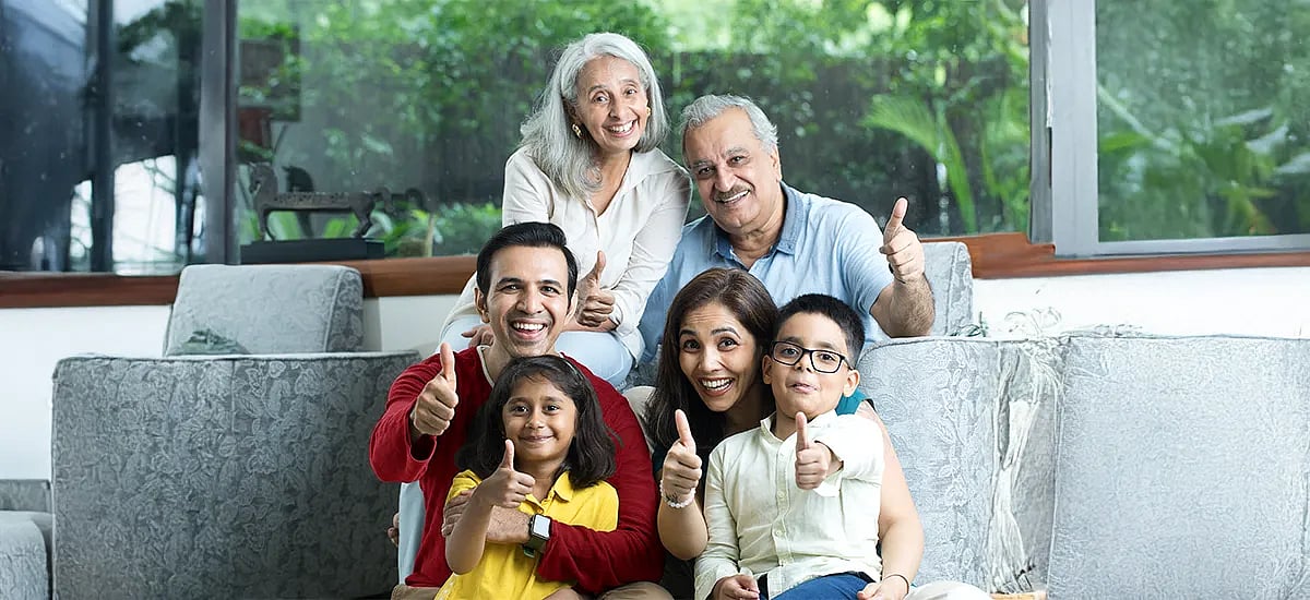 A family sitting together and showing thumbs up