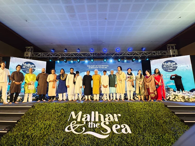 A group of people on a stage at an event called Malhar & The Sea