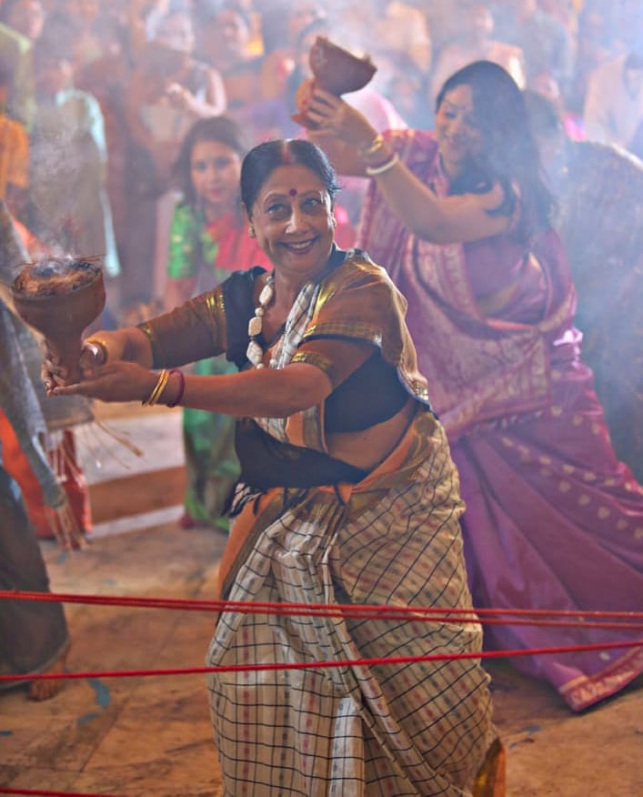 Women in saree performing a dance or ritual inside a pandal