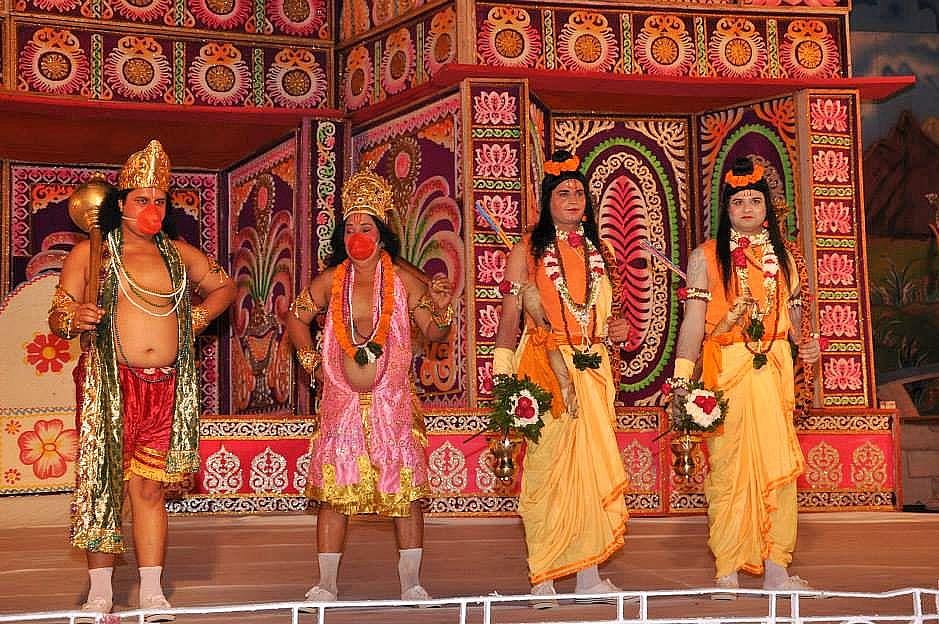 Performers in traditional costumes reenact a scene from the Ramayana on a stage.