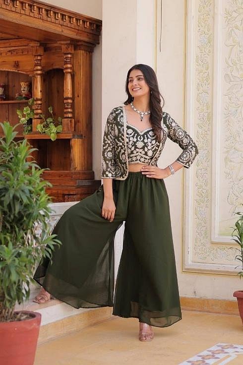 A woman in Indo-Western outfit with crop top, koti, and palazzo pants.