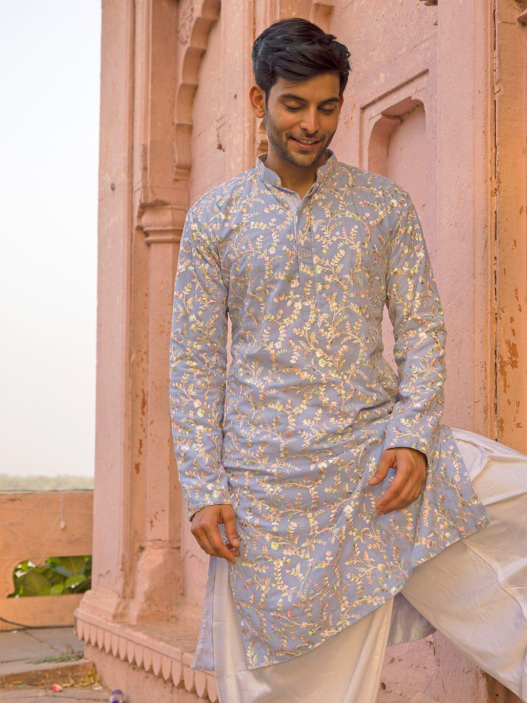 A man wearing a vibrant traditional kurta set.