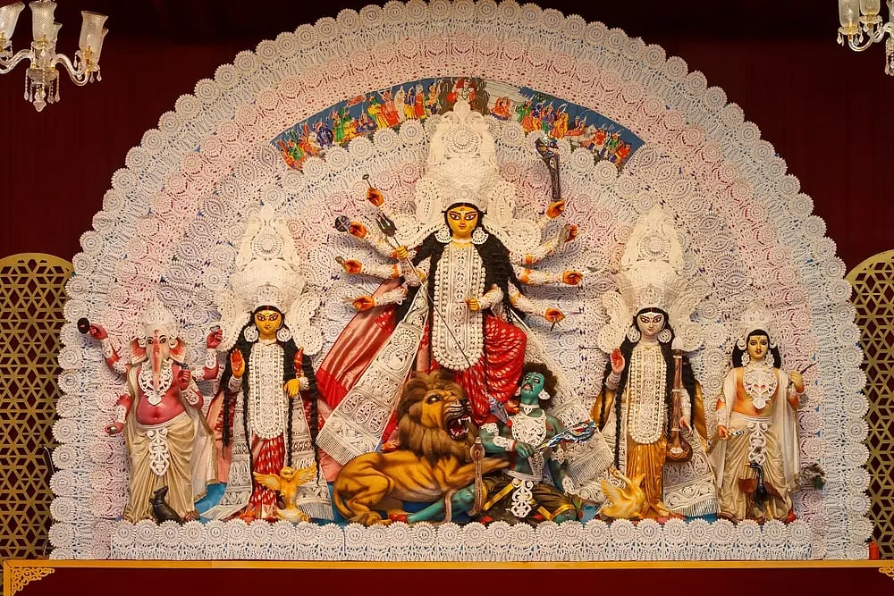 A detailed tableau of the Hindu goddess Durga with other deities in an ornate pandal