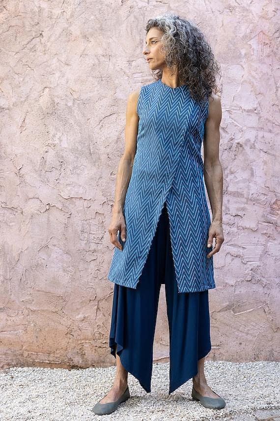 A woman wearing a blue, chevron-patterned ethnic tunic and pants.