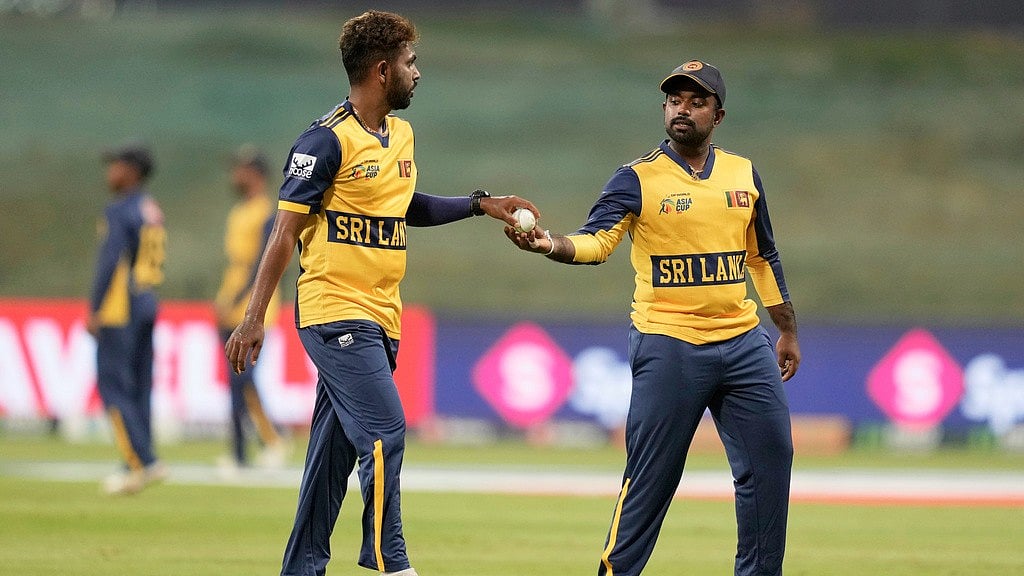 Sri Lanka's captain Charith Asalanka, right, hands the ball to teammate Nuwan Thushara during the Asia Cup match against Bangladesh in Abu Dhabi. - AP