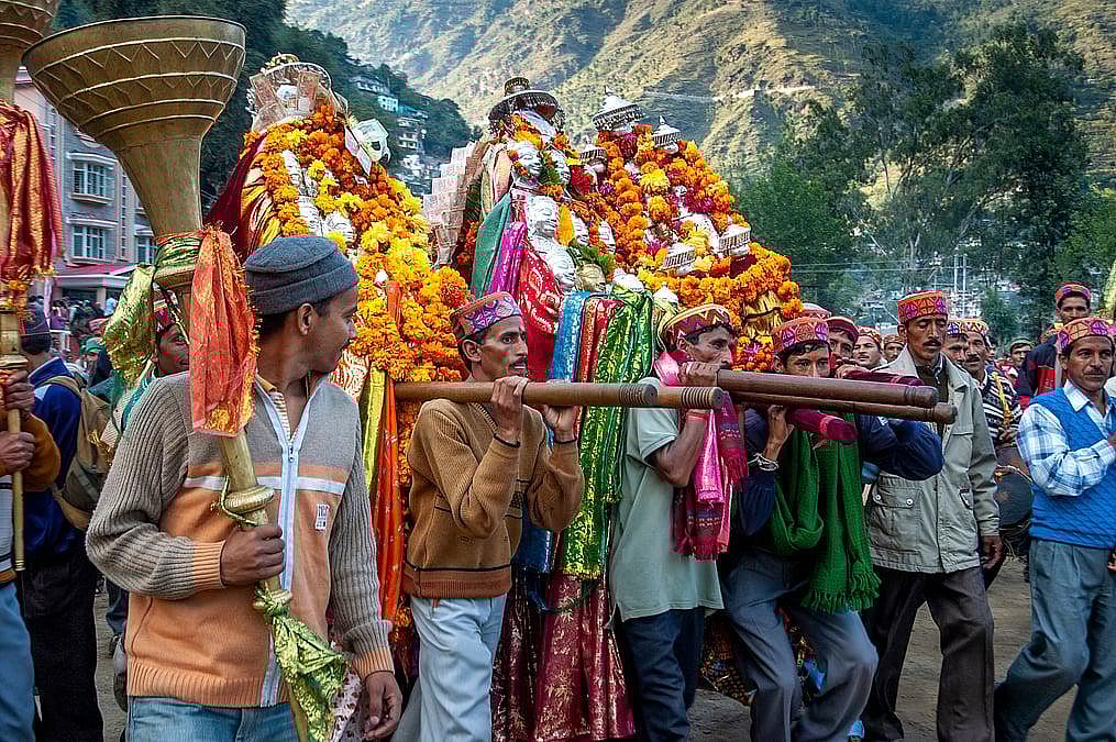 A group of people carrying a decorated palanquin during a religious procession