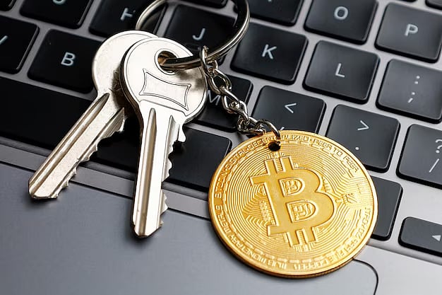 Keys with a Bitcoin keychain placed on a laptop keyboard.