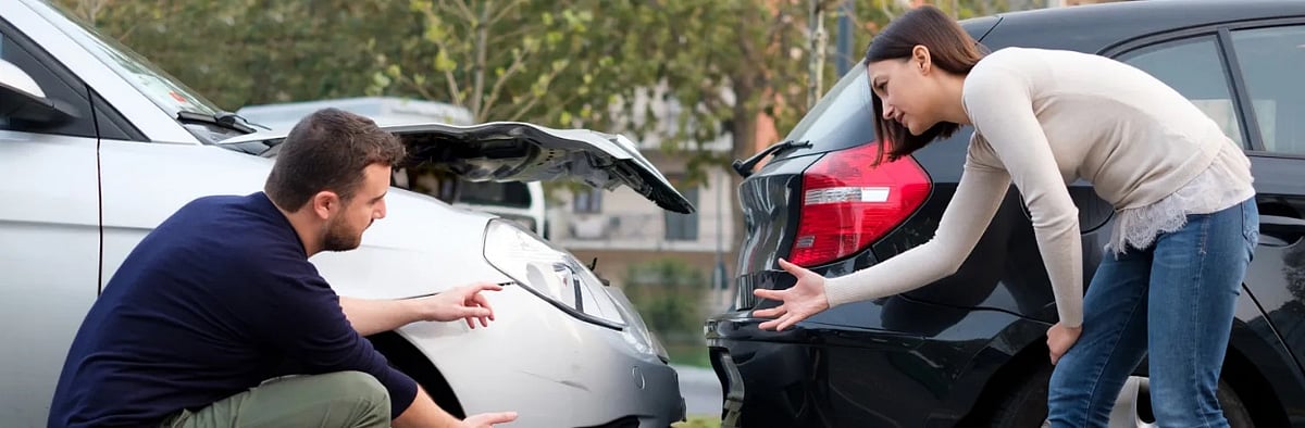 Car accident scene with man and woman arguing over vehicle damage
