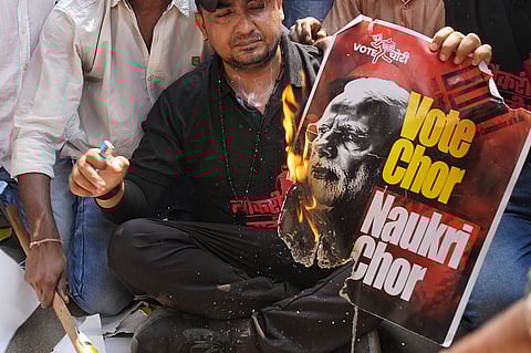 A protestor holds a burning placard. 