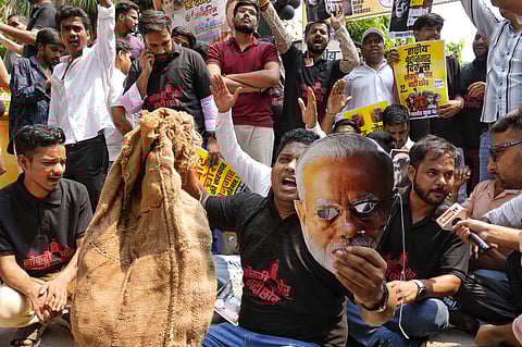 The decoy holds up the Modi mask and the much famous 'jhola'. 