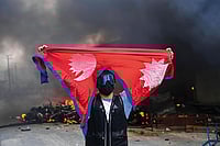 | Photograph: AP : Violent Day: A protester shouts slogans after burning down a police station in Kathmandu