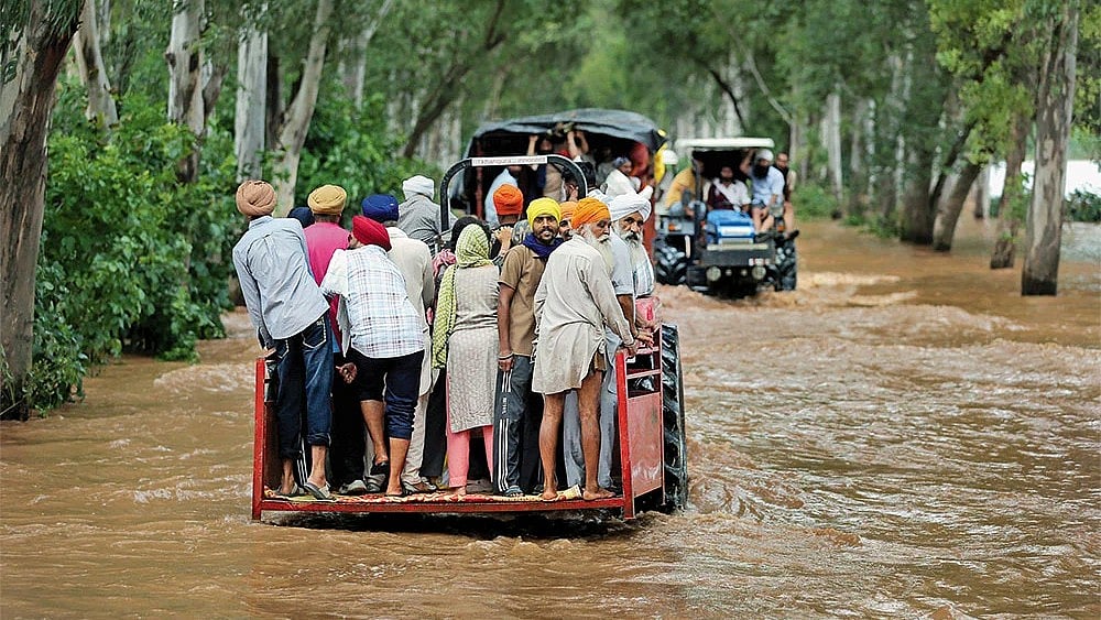 | Photo: Imago/ANI News : The Day After: Villagers commute on tractors through the flood waters at Ghonewala village near the India-Pakistan border on September 4, 2025