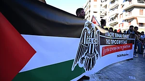 | Photo: AP/Giannis Papanikos : Pro-Palestinian protesters, most of them PAOK fans, hold a banner that reads "PAOK is the child of refugees. No to displacement and genocide" as they gather ahead of a Europa League soccer match between PAOK and Israeli team Maccabi Tel Aviv in the port city of Thessaloniki, northern Greece, Wednesday, Sept. 24, 2025.