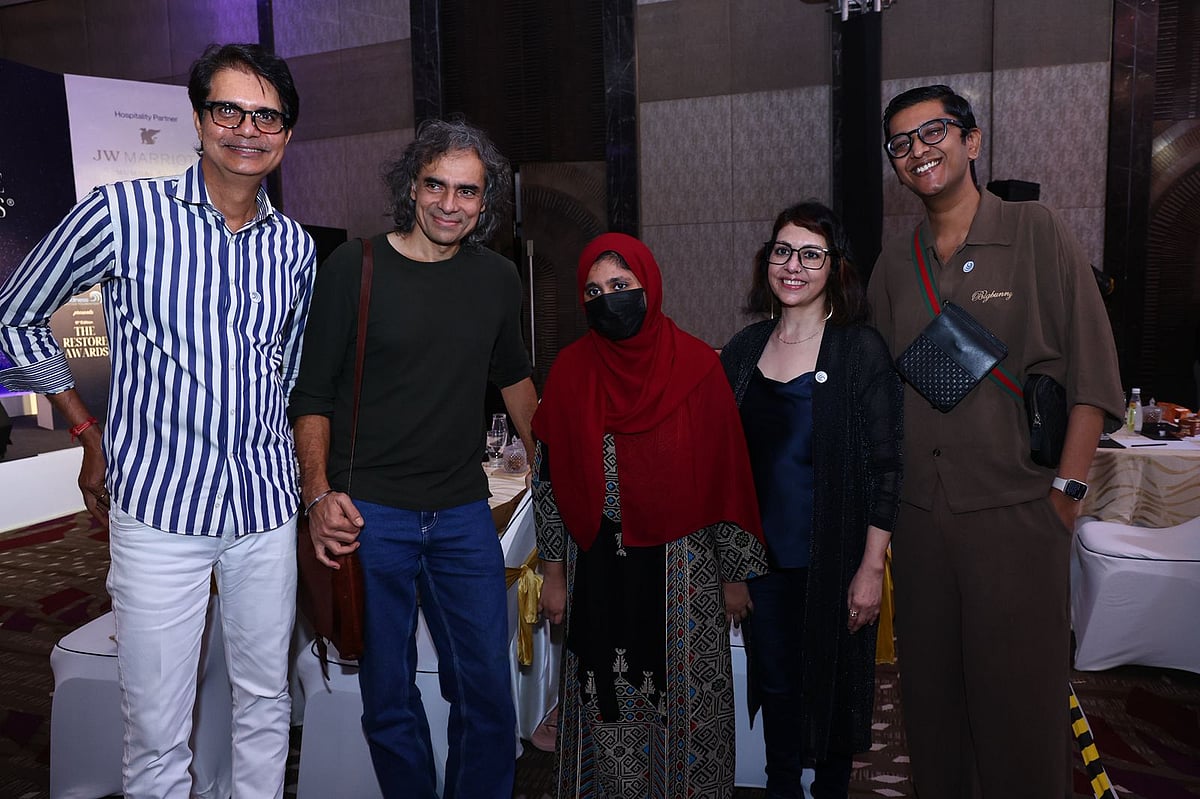 A group photo of five people smiling and posing for the camera.