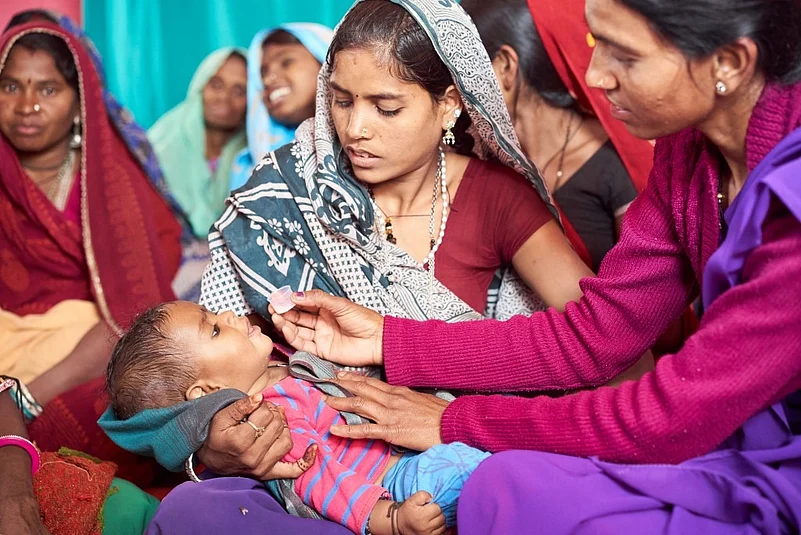 A healthcare worker administering antibiotics to a child