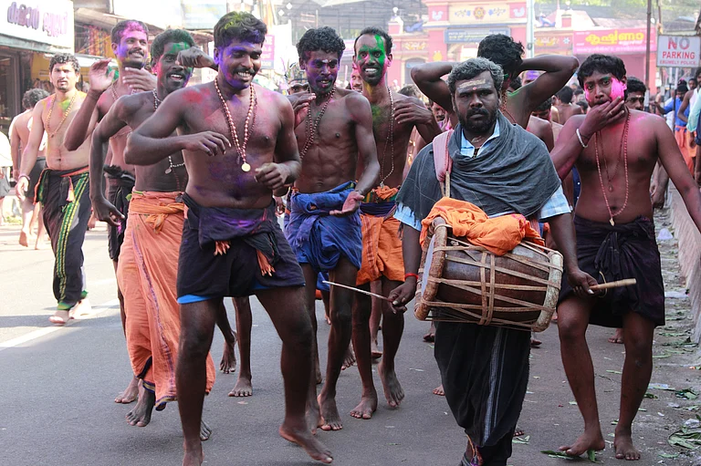 Devotees of Lord Ayyappa sing and dance at a procession on their way to Sabarimala on December16, 2011 in Erumeli, India. Around 50 million visit Sabarimala every year. - Shutterstock