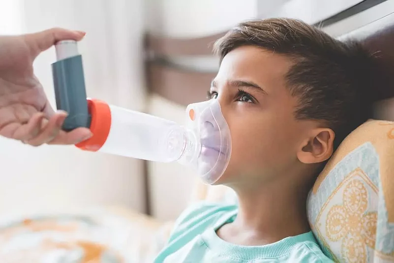 A child given an inhaler to help them breathe