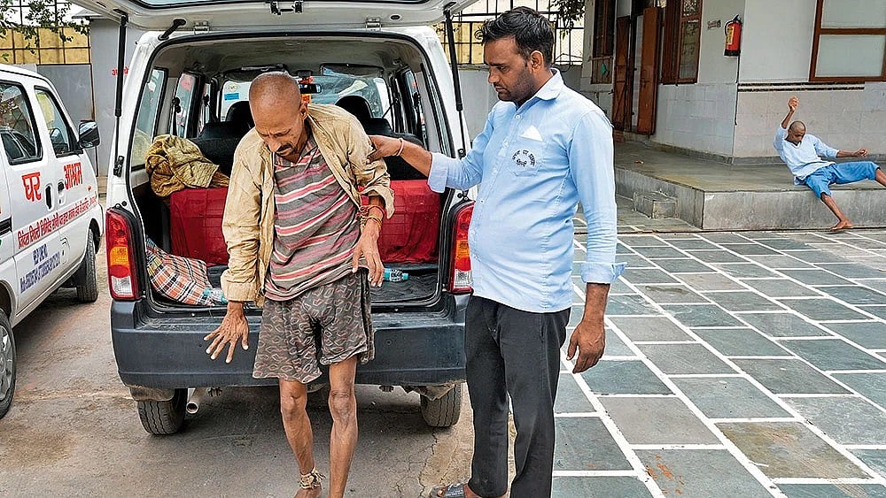 | Photo: Suresh K. Pandey : A Helping Hand: A person who had been living on the streets being brought to Apna Ghar Ashram, which works to unite the homeless with their families once their mental health stabilises