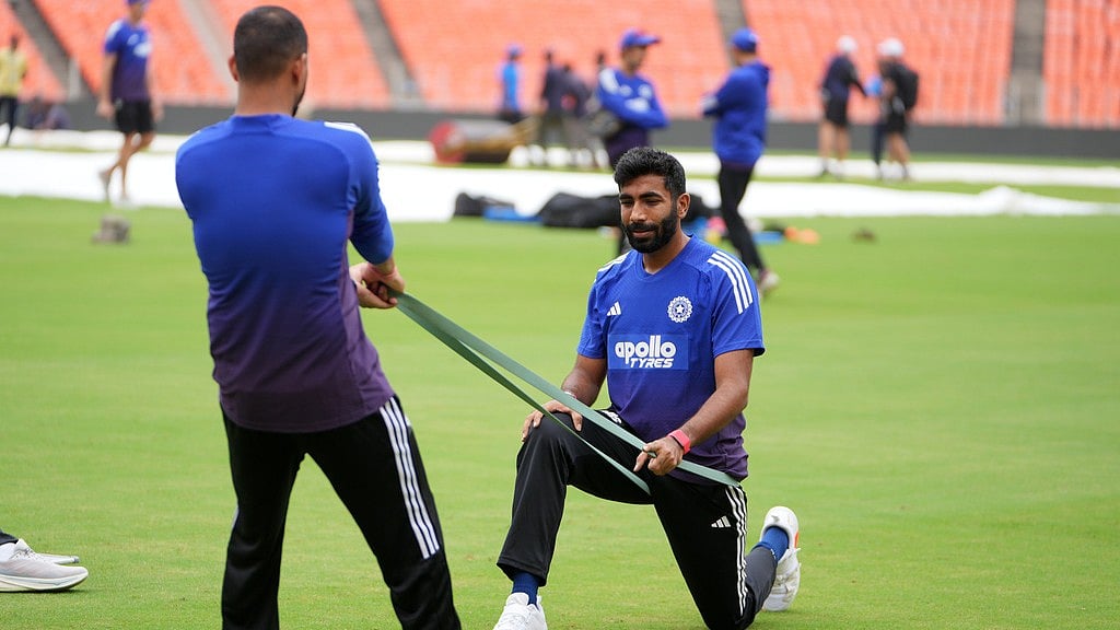 AP : IND vs WI 1st Test Live Cricket Score: India's Jasprit Bumrah, right, stretches during a practice session ahead of the 1st Test against West Indies at Narendra Modi Stadium in Ahmedabad.
