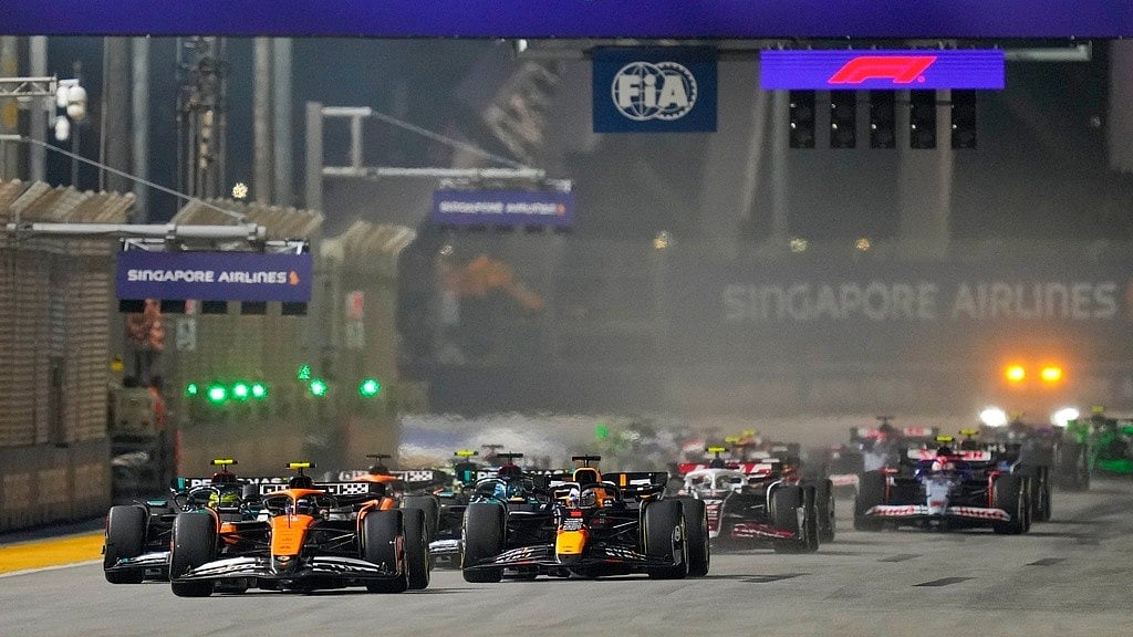 File/AP : McLaren driver Lando Norris of Britain leads the field into turn one at the start of the Singapore Formula One Grand Prix at the Marina Bay Street Circuit.