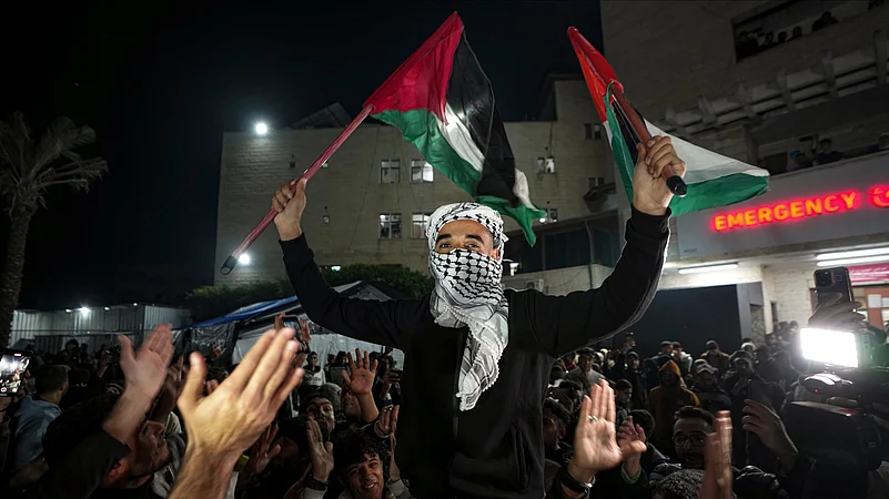 Palestinians celebrate the announcement of a ceasefire deal between Hamas and Israel