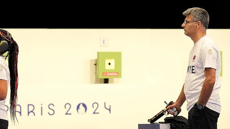 File/AP : Turkish shooter Yusuf Dikec, right, looks on as Turkey's coach talks to Dikec's teammate Sevval Ilayda Tarhan during the 10m air pistol mixed team final at the Paris Olympics.