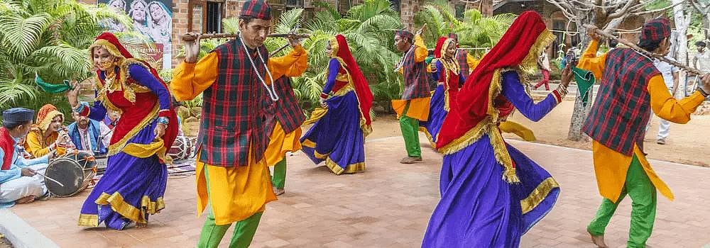 A group of people in traditional attire perform a folk dance, possibly chholiya dance