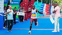 Special Arrangement : Kenya’s Alex Matata (centre) crosses the finish line to win the men's title at Delhi Half Marathon 2025.