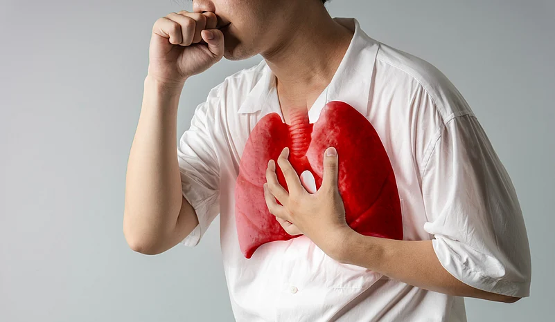 A man coughing with an illustration of lungs in red colour