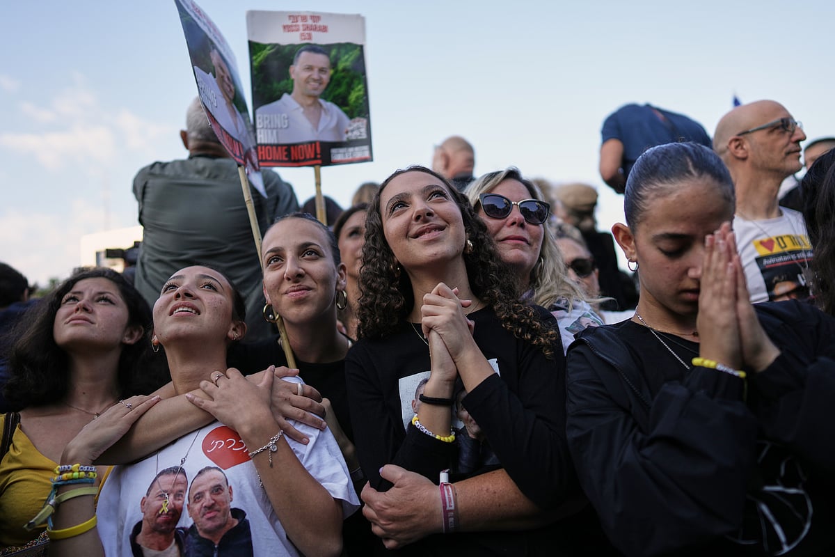 AP Photo/Oded Balilty : People react as they gather to watch a live broadcast of Israeli hostages released from Gaza at a plaza known as hostages square in Tel Aviv, Israel, Monday, Oct. 13, 2025. The release took place as part of a cease-fire agreement between Israel and Hamas.