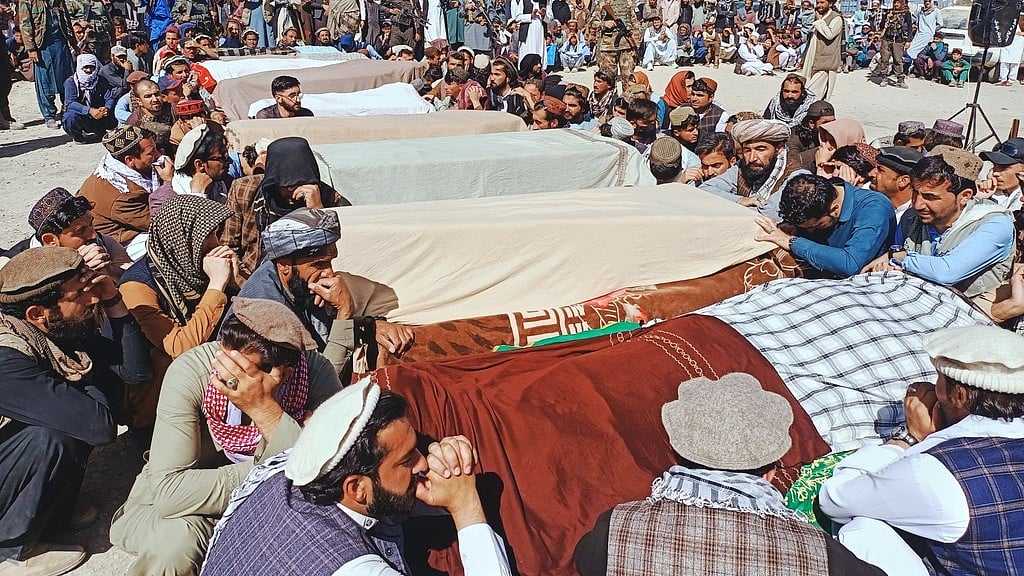 AP : Local residents pray over the bodies of victims of a Pakistani cross-border airstrike, including three local cricketers, during a funeral in the village of Khandaro in the Argun district of Afghanistan's eastern Paktika province.