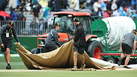 AP Photo : Groundsmen lay covers on the pitch as rain stops play during the one-day international cricket match between Australia and India in Perth.