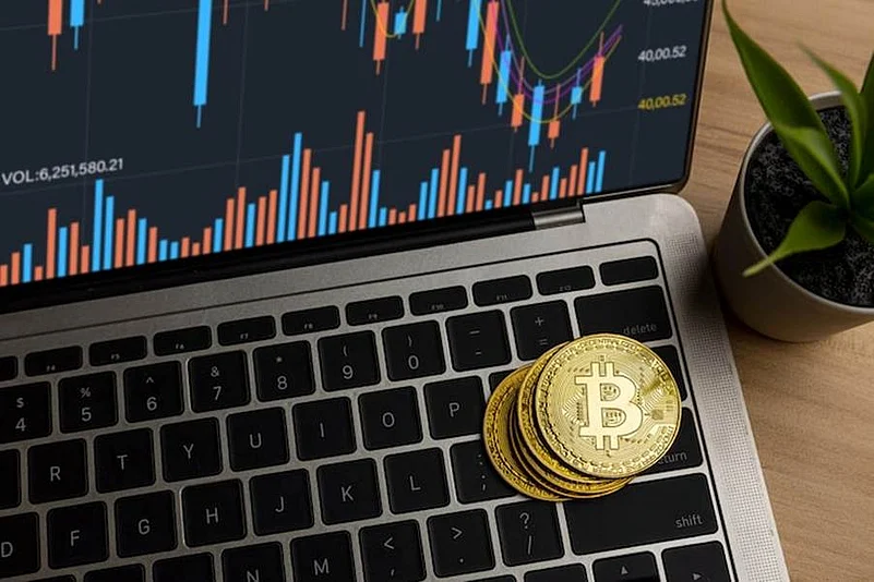 Bitcoin coins on a laptop with a crypto chart