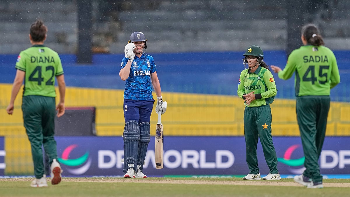 England's Em Arlott and others look on as the rain interrupts the play during the ICC Women's Cricket World Cup match between England and Pakistan at Premadasa Stadium in Colombo, Sri Lanka, Wednesday, Oct, 15, 2025. - | Photo: AP/Eranga Jayawardena