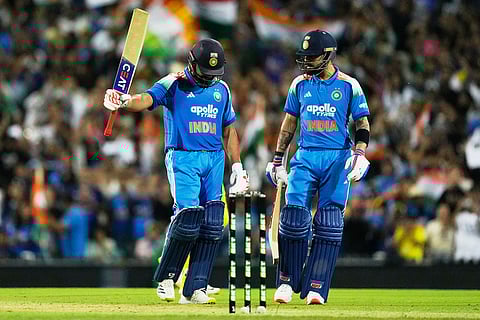 India's Rohit Sharma, left, raises his bat after making 100 runs against Australia as teammate Virat Kohli watches during their One Day International cricket match in Sydney, Australia.