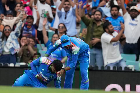 India's Shreyas Iyer, left, is injured after catching out Australia's Alex Carey during their One Day International cricket match in Sydney, Australia.