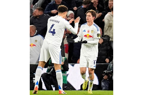 Leeds United's Brenden Aaronson, right, celebrates with Ethan Ampadu after scoring their side's first goal of the game during the English Premier League soccer match between Leeds United and West Ham United in Leeds, England.