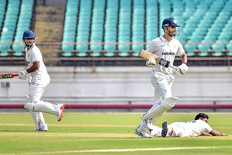 Saurashtra's Chirag Jani and Harvik Desai run between the wickets during the Ranji Trophy cricket match between Saurashtra and Madhya Pradesh, at Niranjan Shah Stadium, in Rajkot, Gujarat.