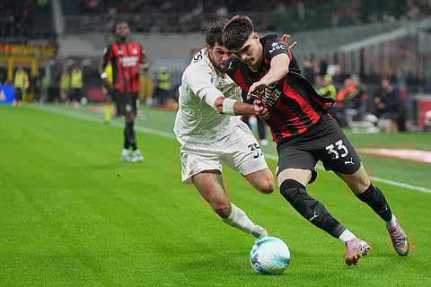 Pisa's Arturo Calabresi, left, and AC Milan's Davide Bartesaghi fight for the ball during the Serie A soccer match between AC Milan and Pisa in Milan, Italy.